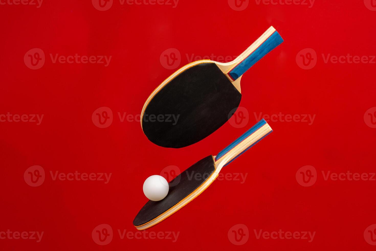 Black ping pong rackets on red background photo