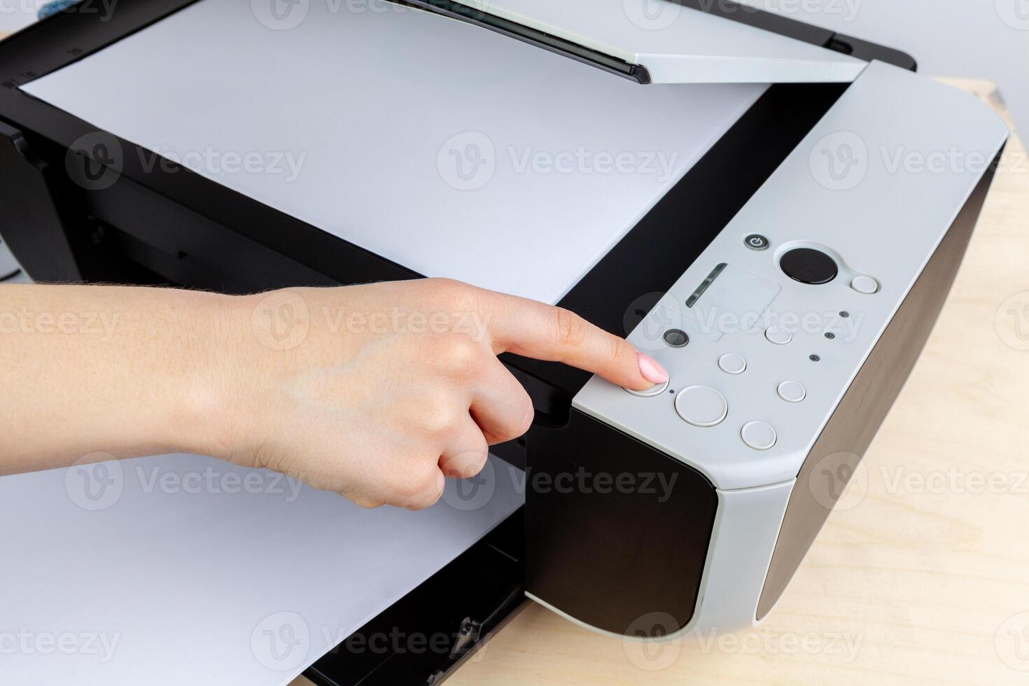 Hands of a woman using a copying machine close up photo