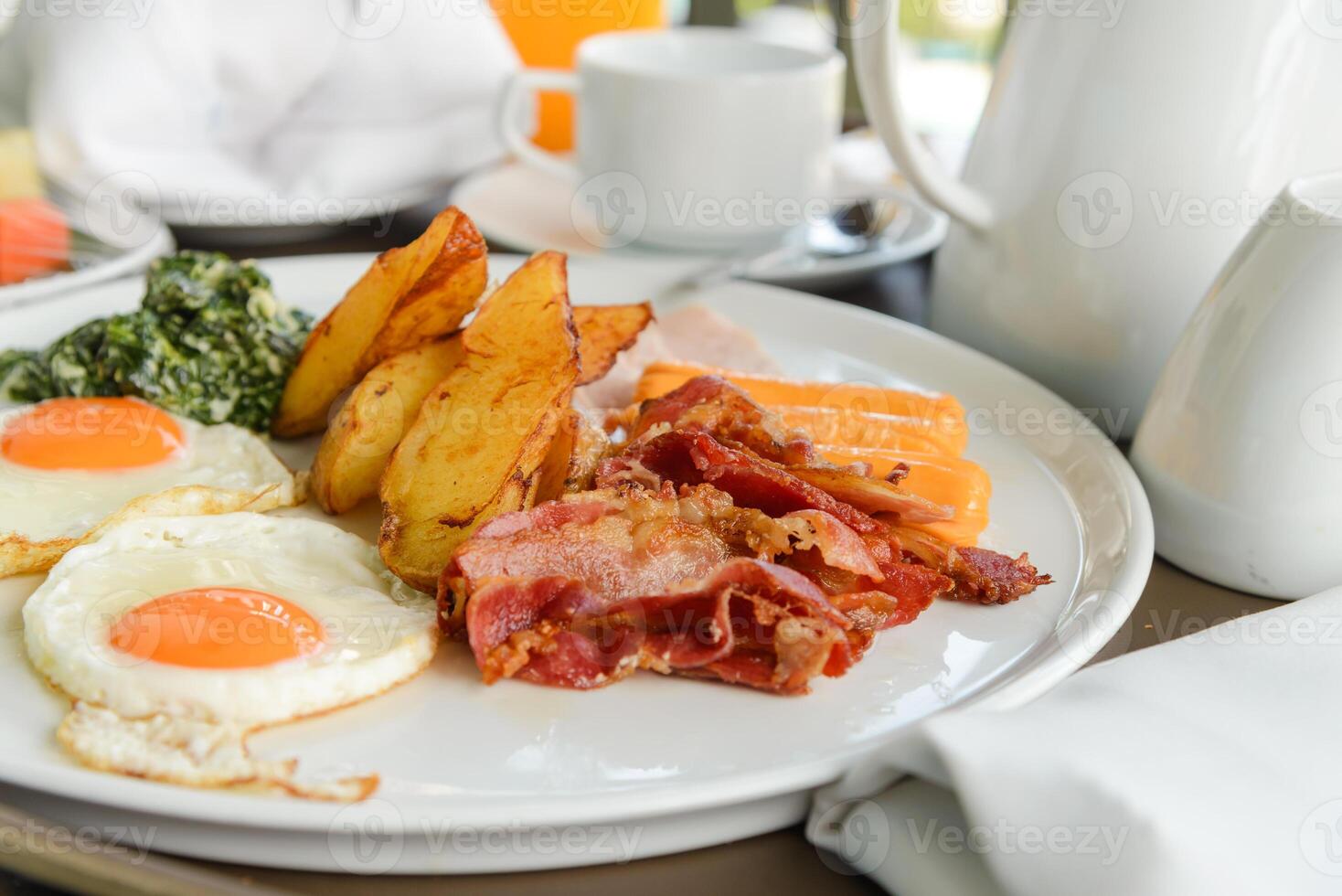 Breakfast consists of eggs, bacon, sausage, bacon, potato and spinach with cheese. delicious on the morning photo