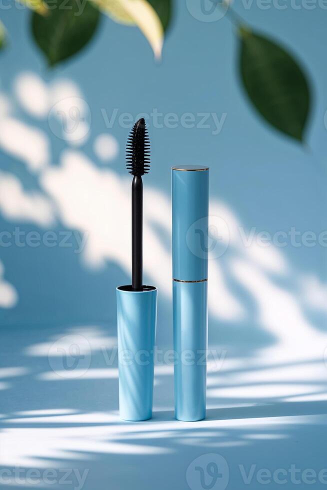 Elegant blue mascara tube with black applicator displayed against a soft background illuminated by natural light photo