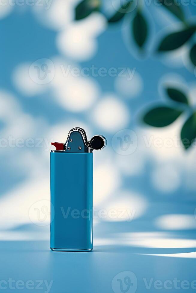 Bright blue lighter stands out against a soft blue background with natural light and shadows photo