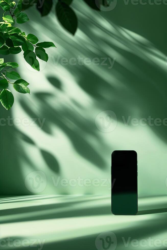 Smartphone casting shadows against a green backdrop with leaves, highlighting modern design and nature's touch photo