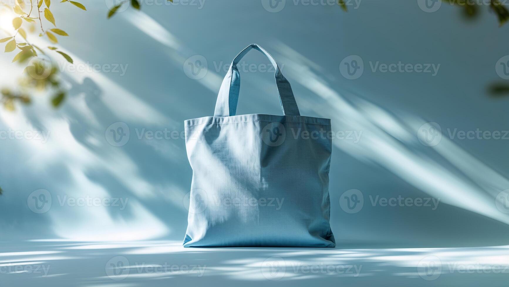 Light blue tote bag displayed with natural shadows creating a tranquil atmosphere in a bright setting photo