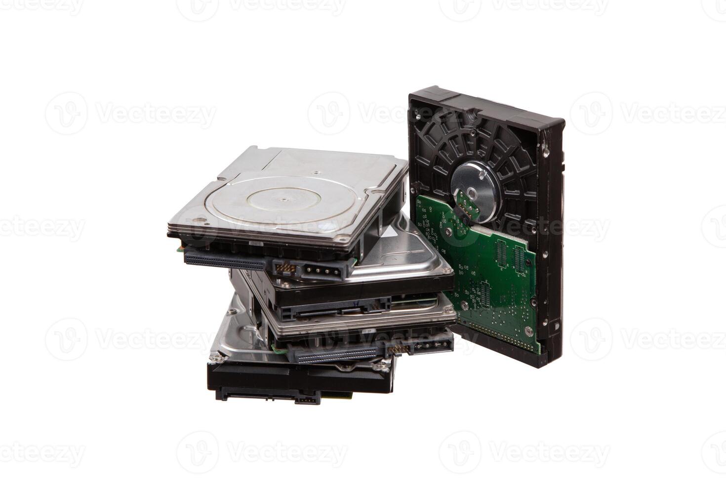 A collection of outdated and potentially non-working hard drives, isolated on a white background, revealing their internal parts and connectors. photo