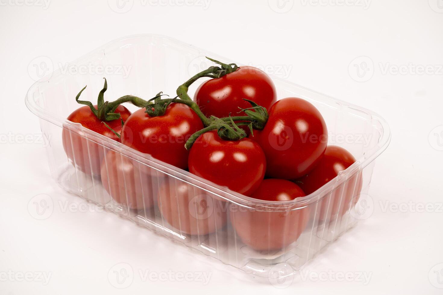 Fresh red tomatoes in a clear plastic container ready for use photo
