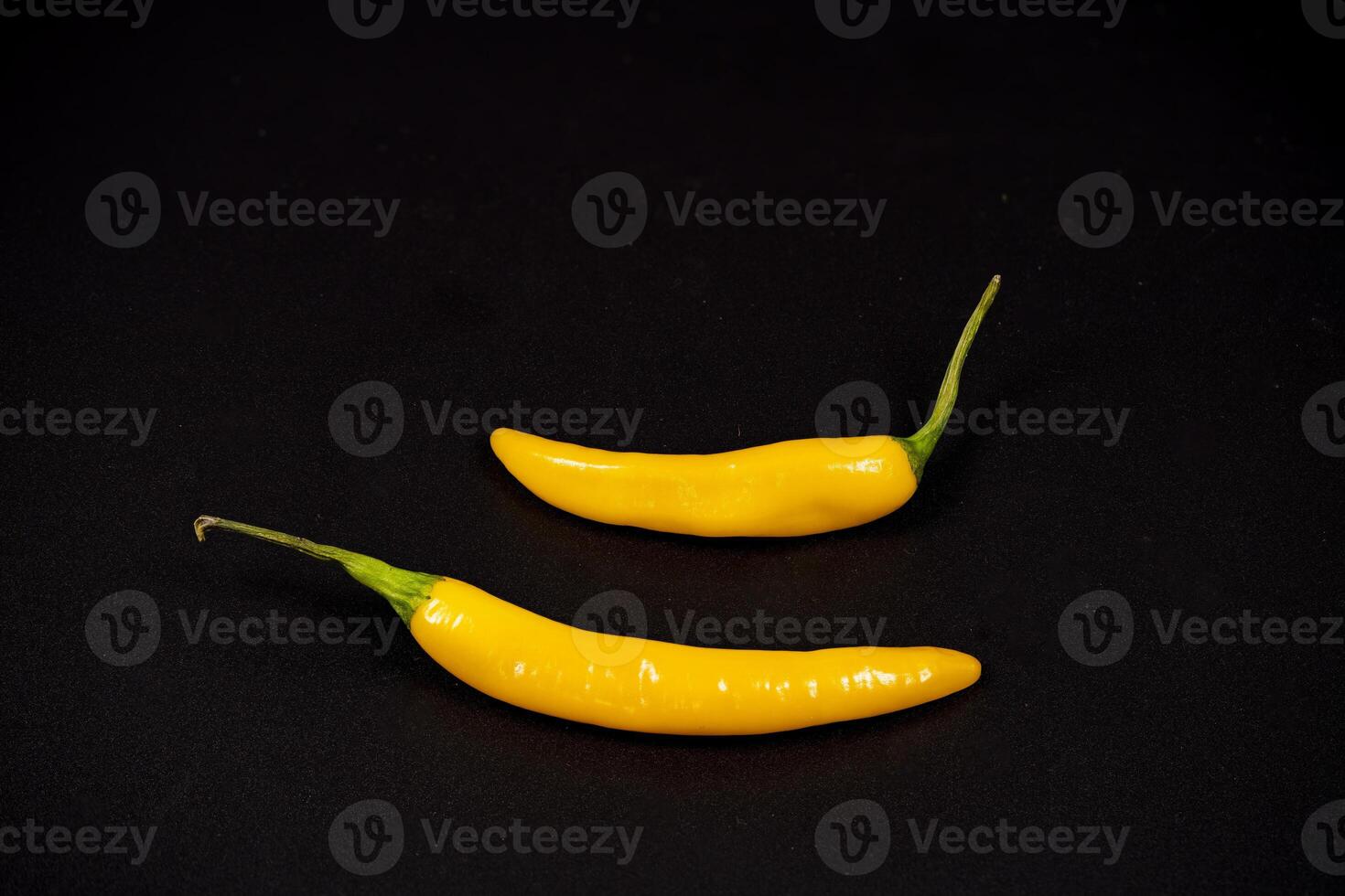Yellow chili peppers on a dark background create a vibrant contrast photo