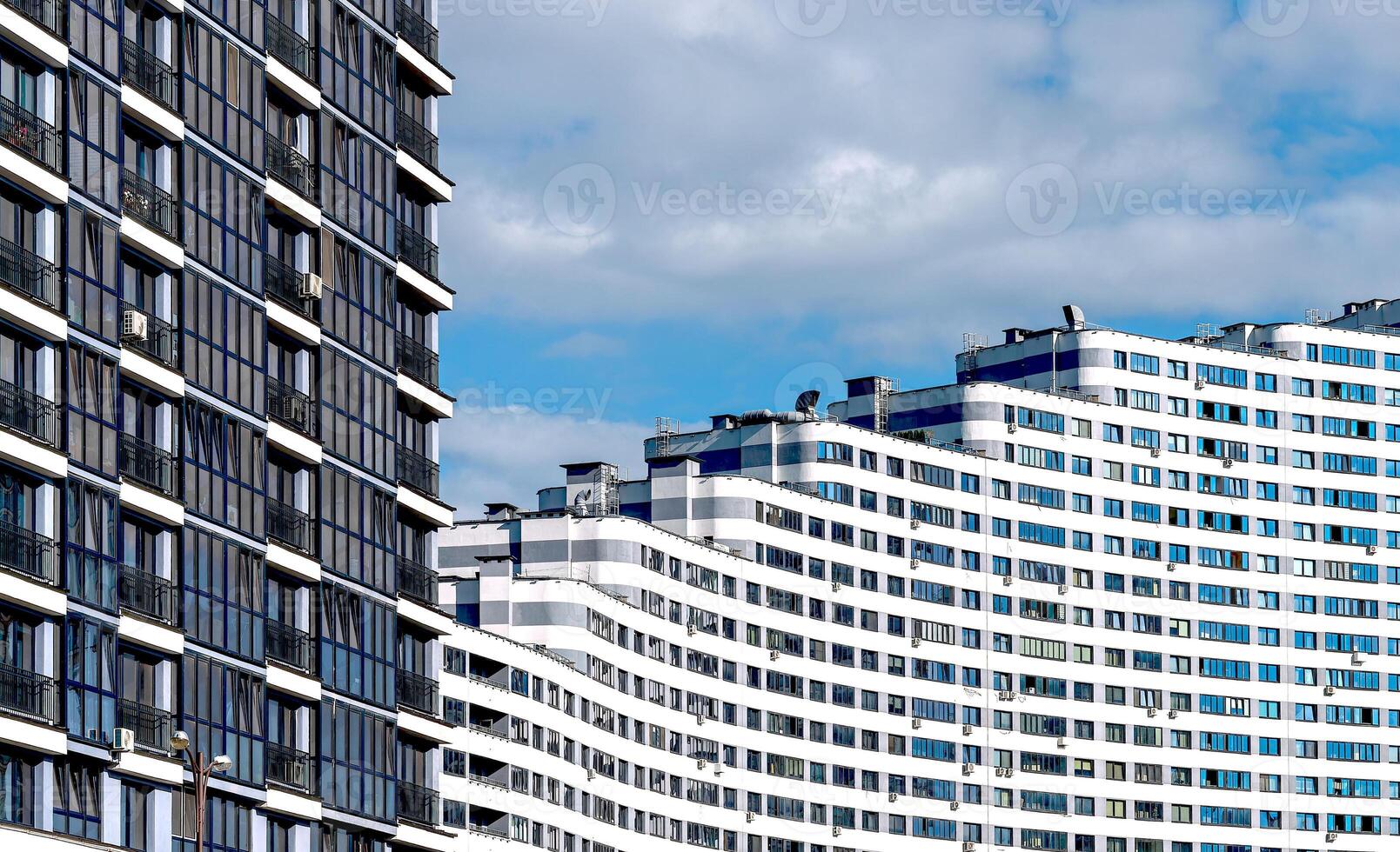 Modern high-rise condominium in downtown metropolis. Concrete structure with wavy, geometric facade, photo