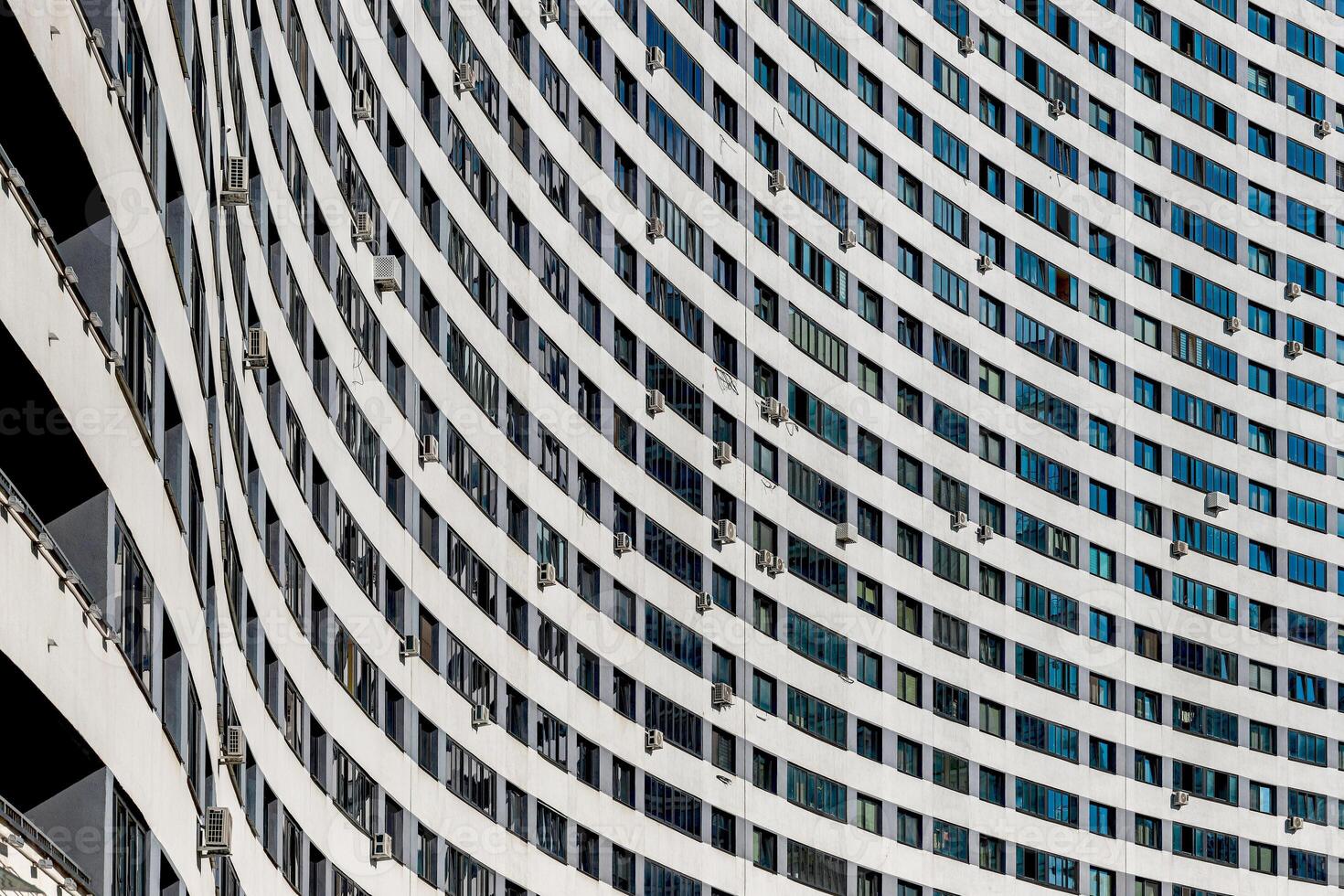 Modern multistory residential building with a sleek concrete facade in a vibrant urban neighborhood. photo