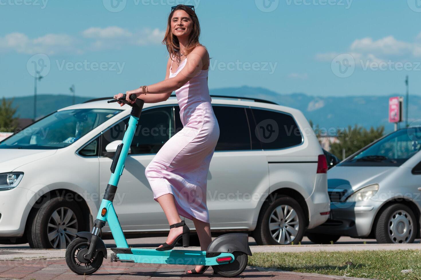 Elegant woman in a pink dress and sunglasses riding an electric scooter through the sunny city streets, embracing the freedom and style of a perfect urban adventure. photo