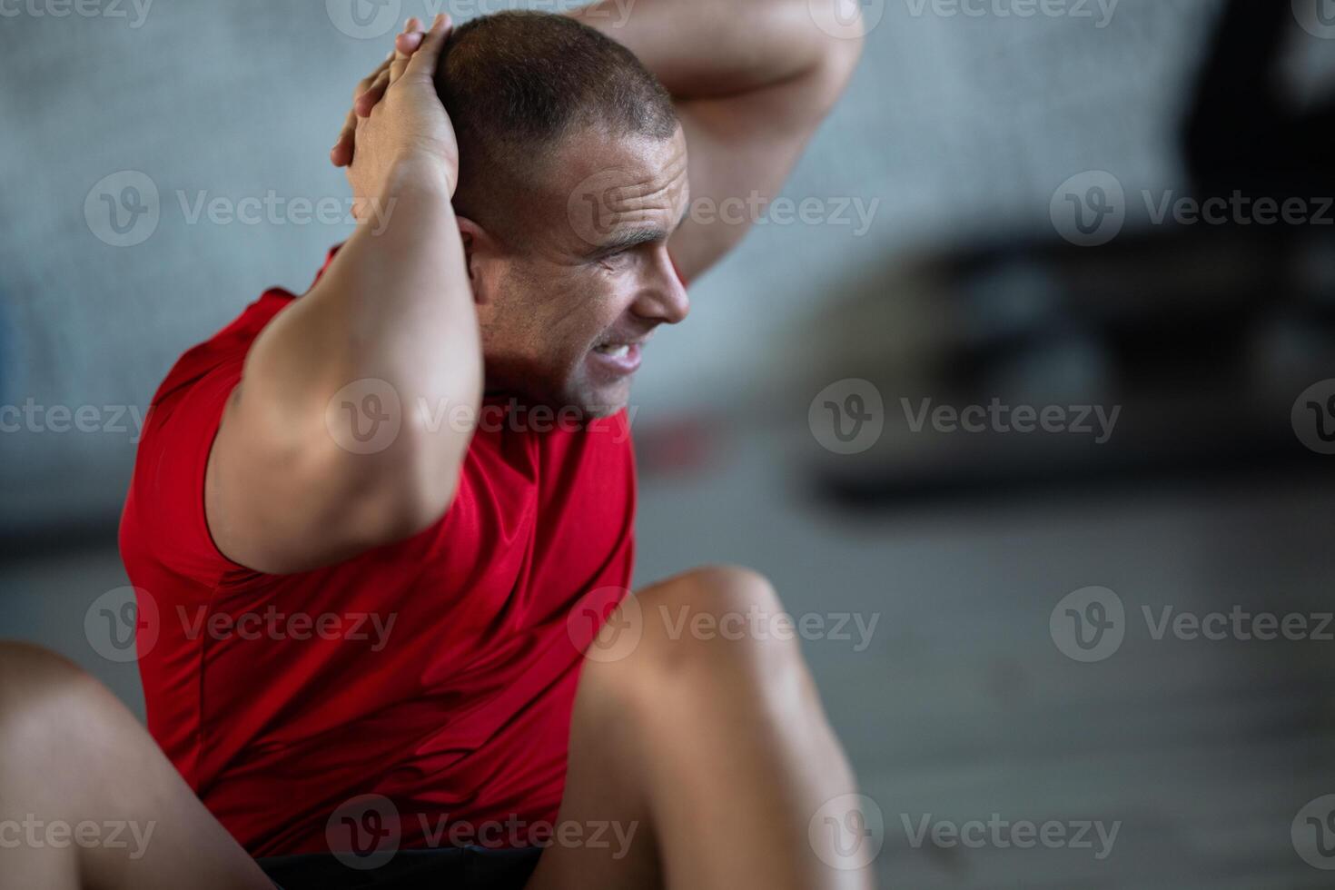 A muscular man performing crunches in the gym, focusing on building core strength and achieving his fitness goals photo