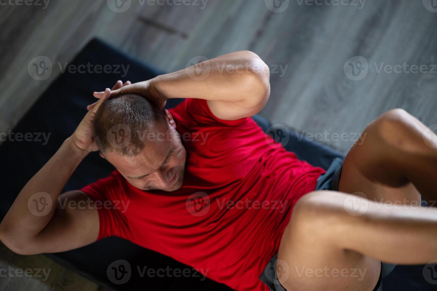 A muscular man performing crunches in the gym, focusing on building core strength and achieving his fitness goals photo