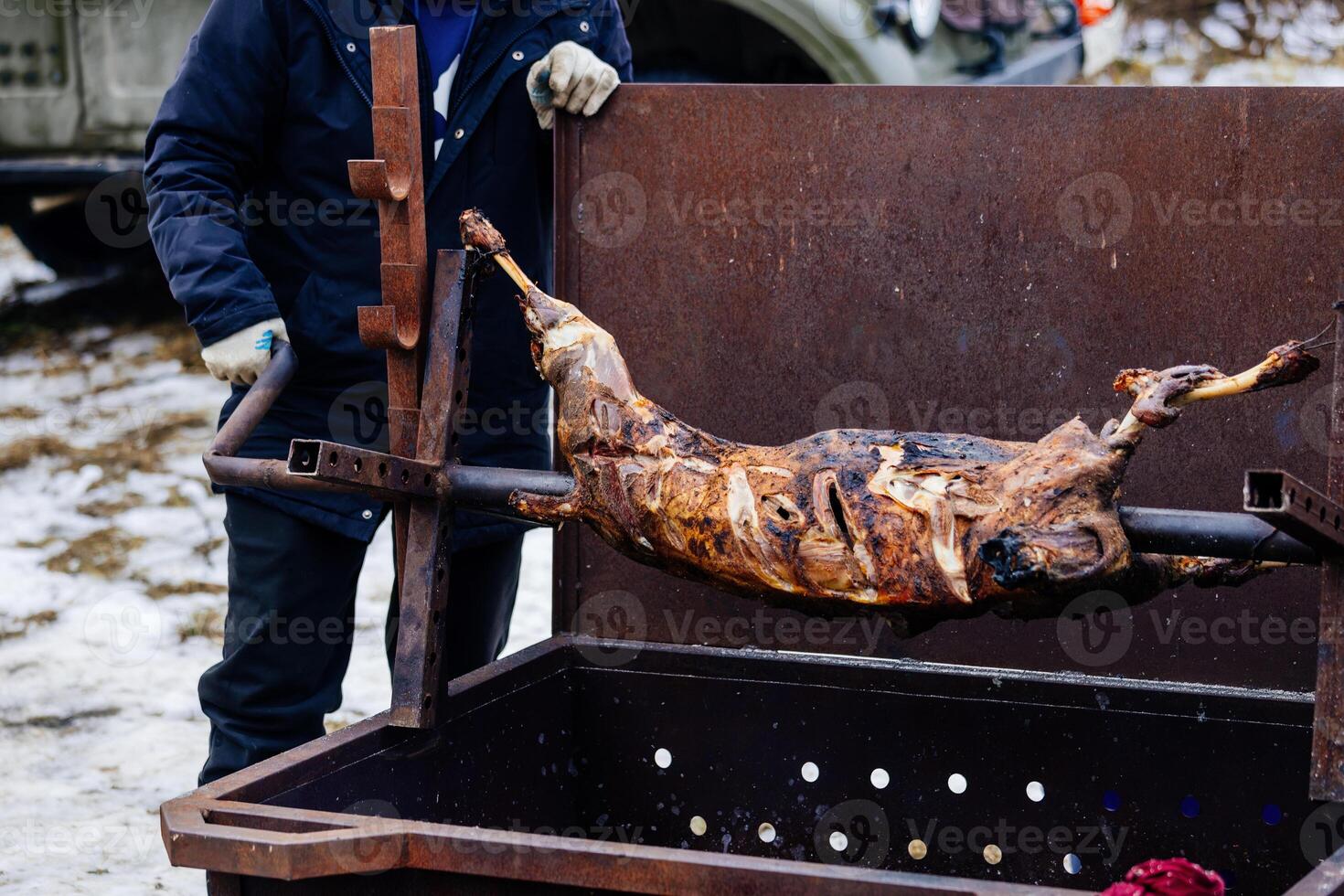 Man frying lamb on barbecue spit. photo