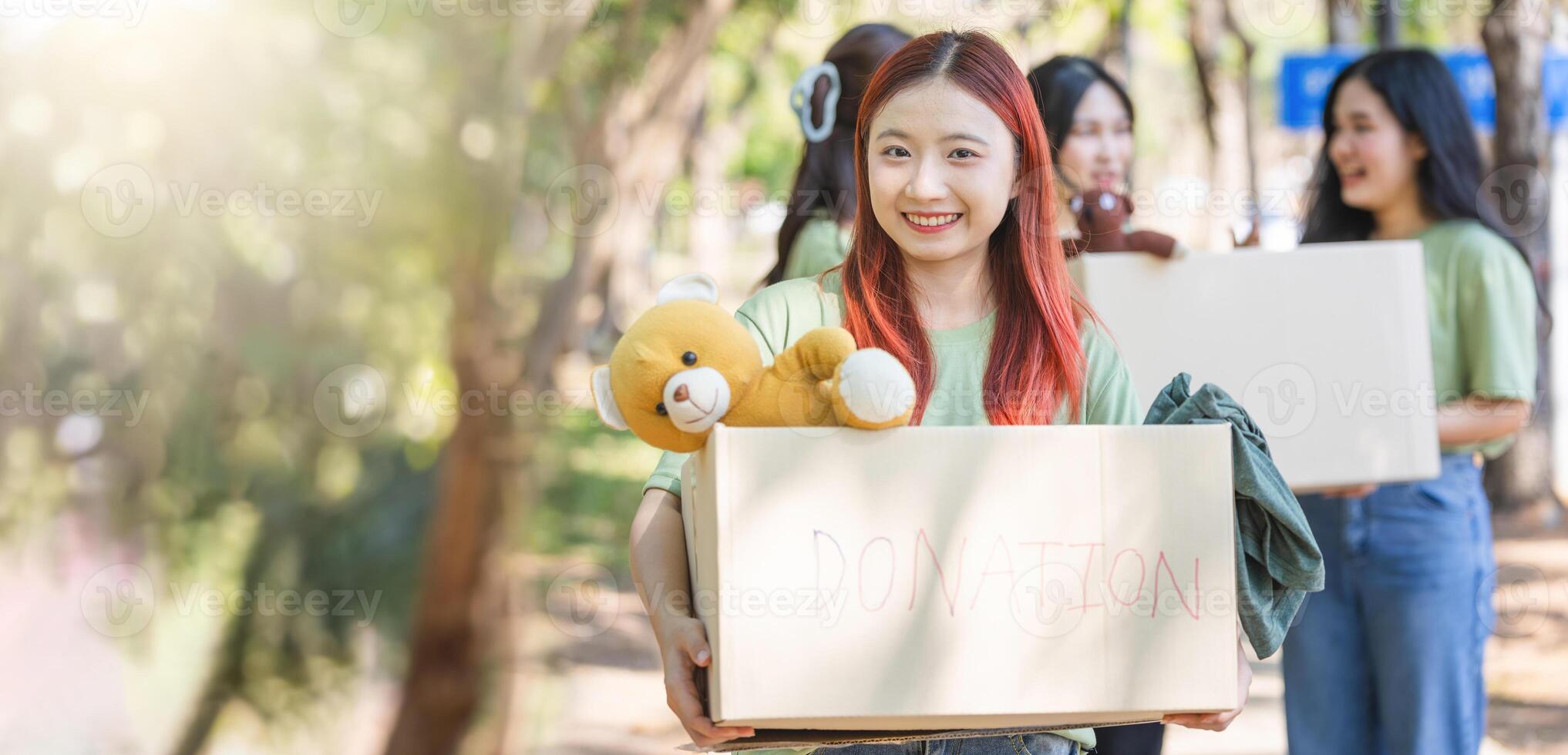 Smiling Woman Carrying a Donation Box, Helping Hands, Group of Volunteers Holding Donation Boxes photo