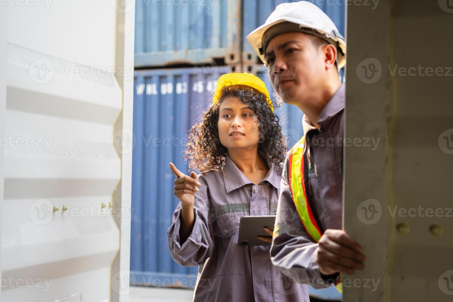 Logistics team discussion at shipping yard, Container yard workers and supervisor reviewing documents, Foreman dock worker in hard hat checking contrainer box at cargo containers photo