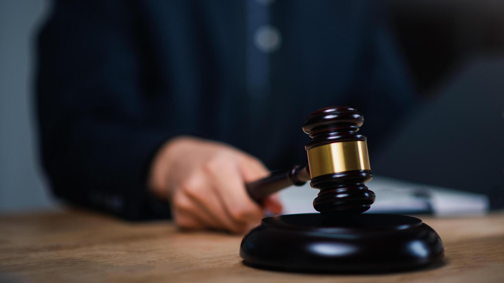 concept of law and justice ,Lawyer or judge examining documents ,legal service lawyer ,legal contract consulting,Wooden judge gavel on table ,justice in punishment of offenses and criminal verdicts photo