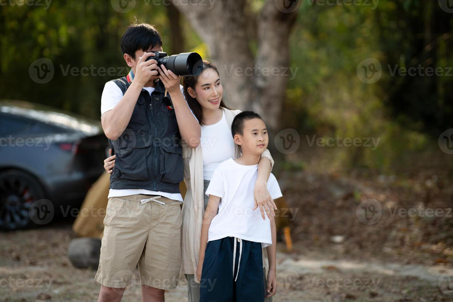 Mother and son is looking at the scenery while the father is taking photos. Family trip, Go Camping. photo