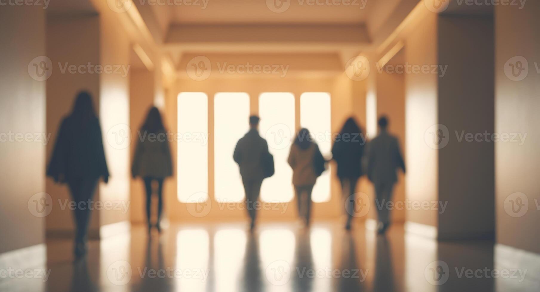 Blurred image of people walking with beautiful warm lighting in a hall. photo