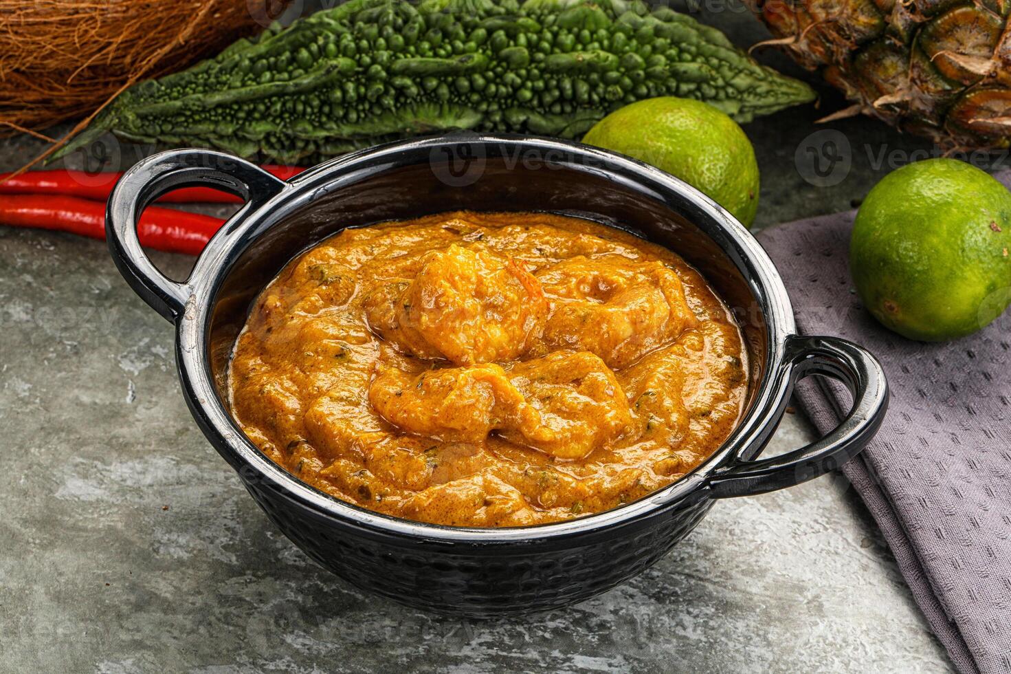 A bowl of curry with a coconut and some other ingredients photo