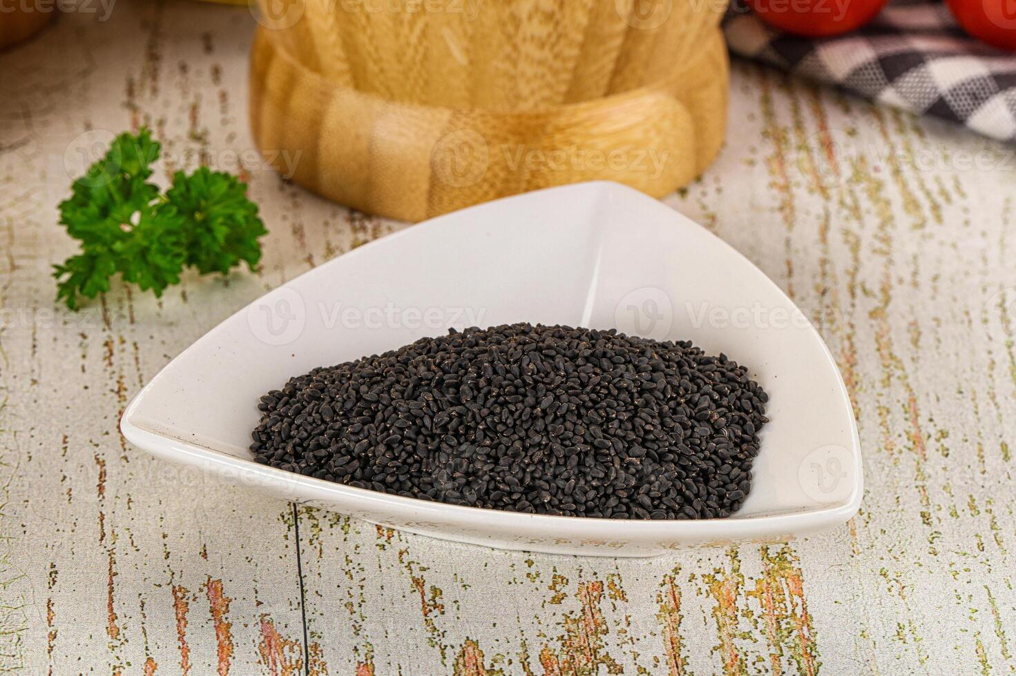 A bowl of black seeds on a table photo