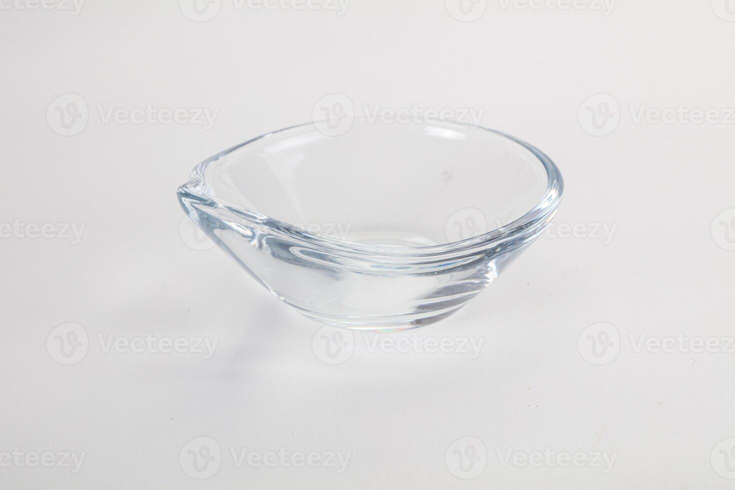 A glass bowl with a curved edge on a white surface photo