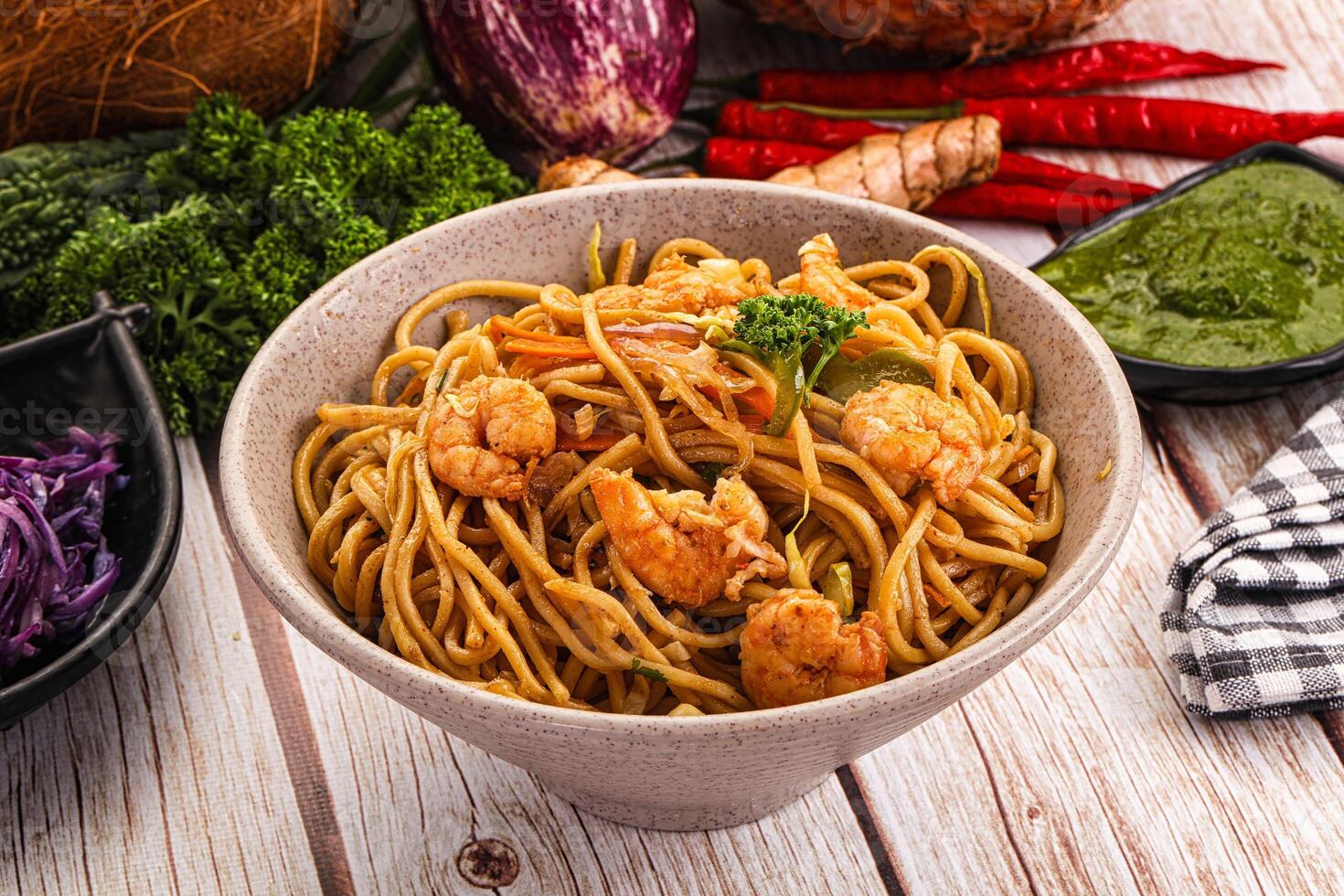 A bowl of noodles and vegetables on a table photo