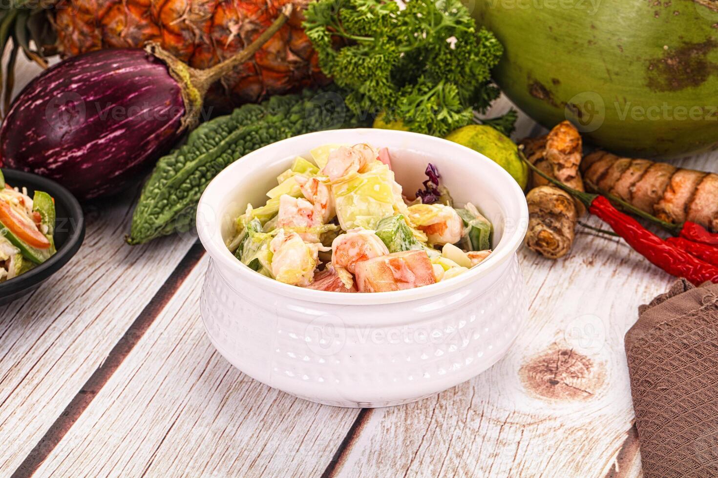 A bowl of salad with a coconut and a bunch of other vegetables photo