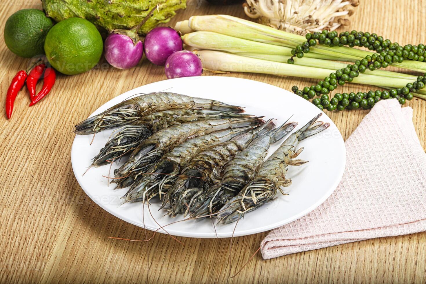 A plate of shrimp on a table with other vegetables photo