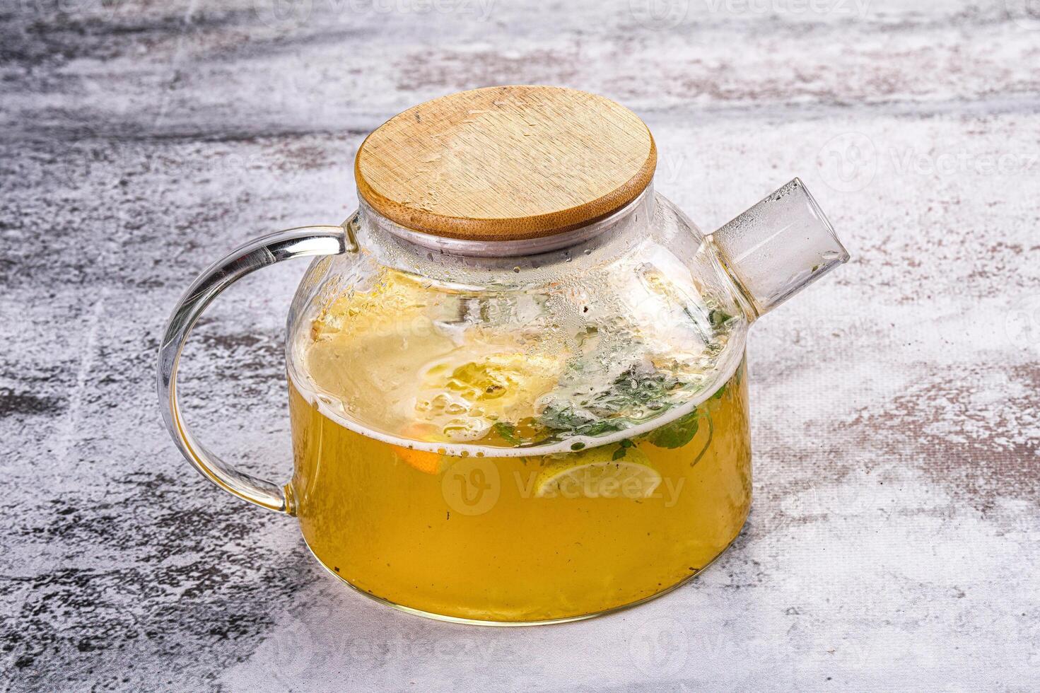 A glass pitcher with lemonade and a wooden lid photo