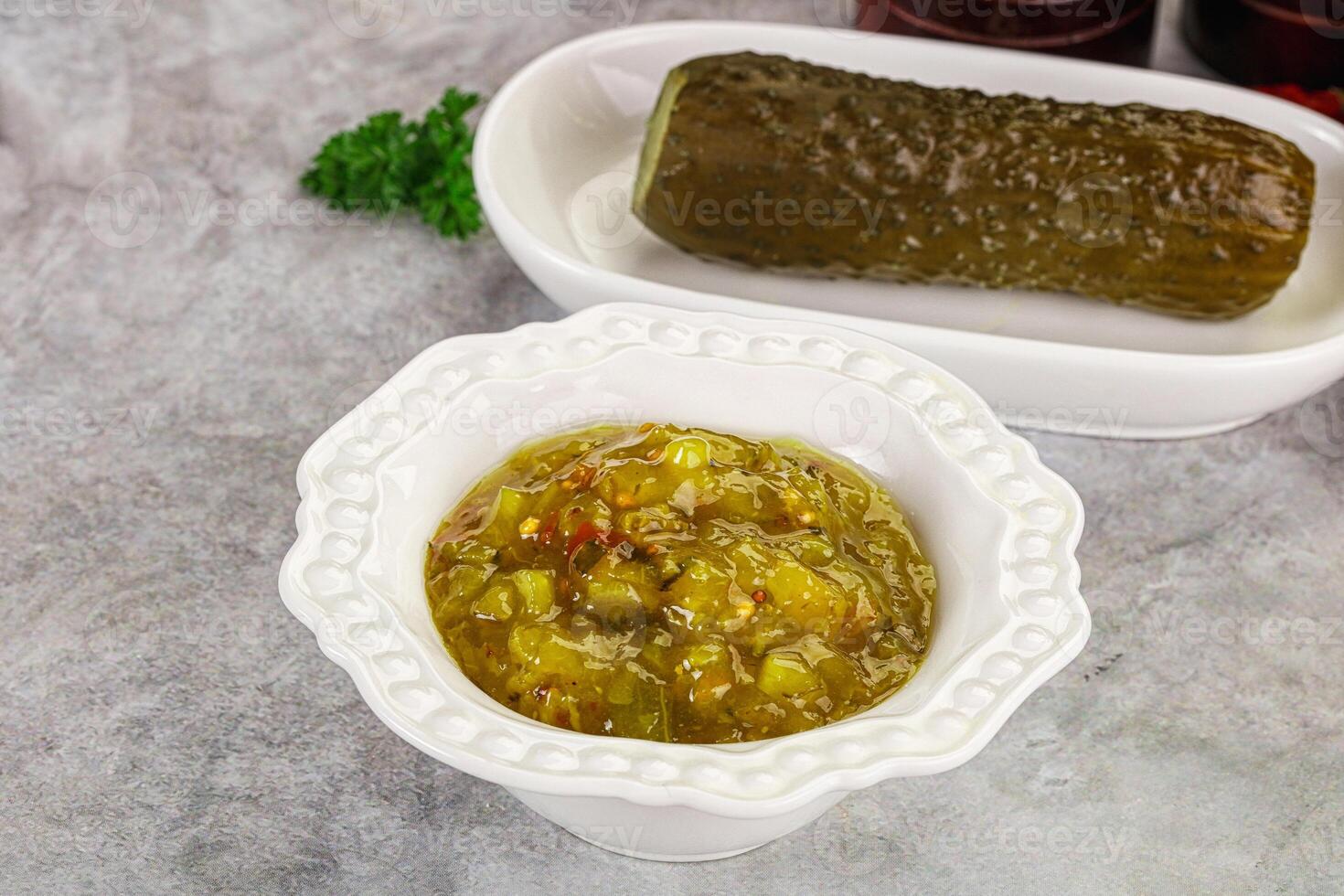A bowl of pickles and a pickle in a white dish photo
