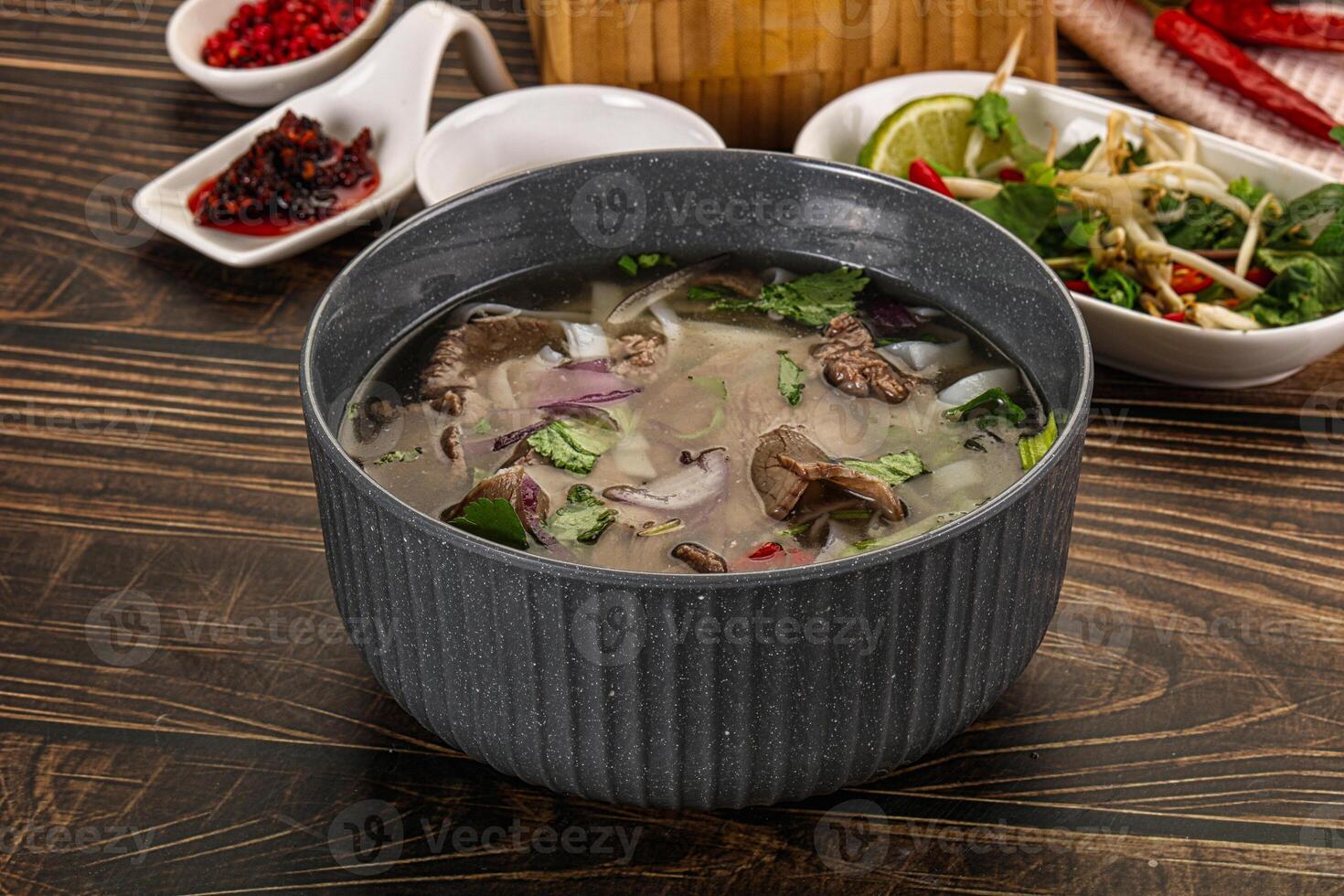 A bowl of soup on a table with a bowl of salad photo