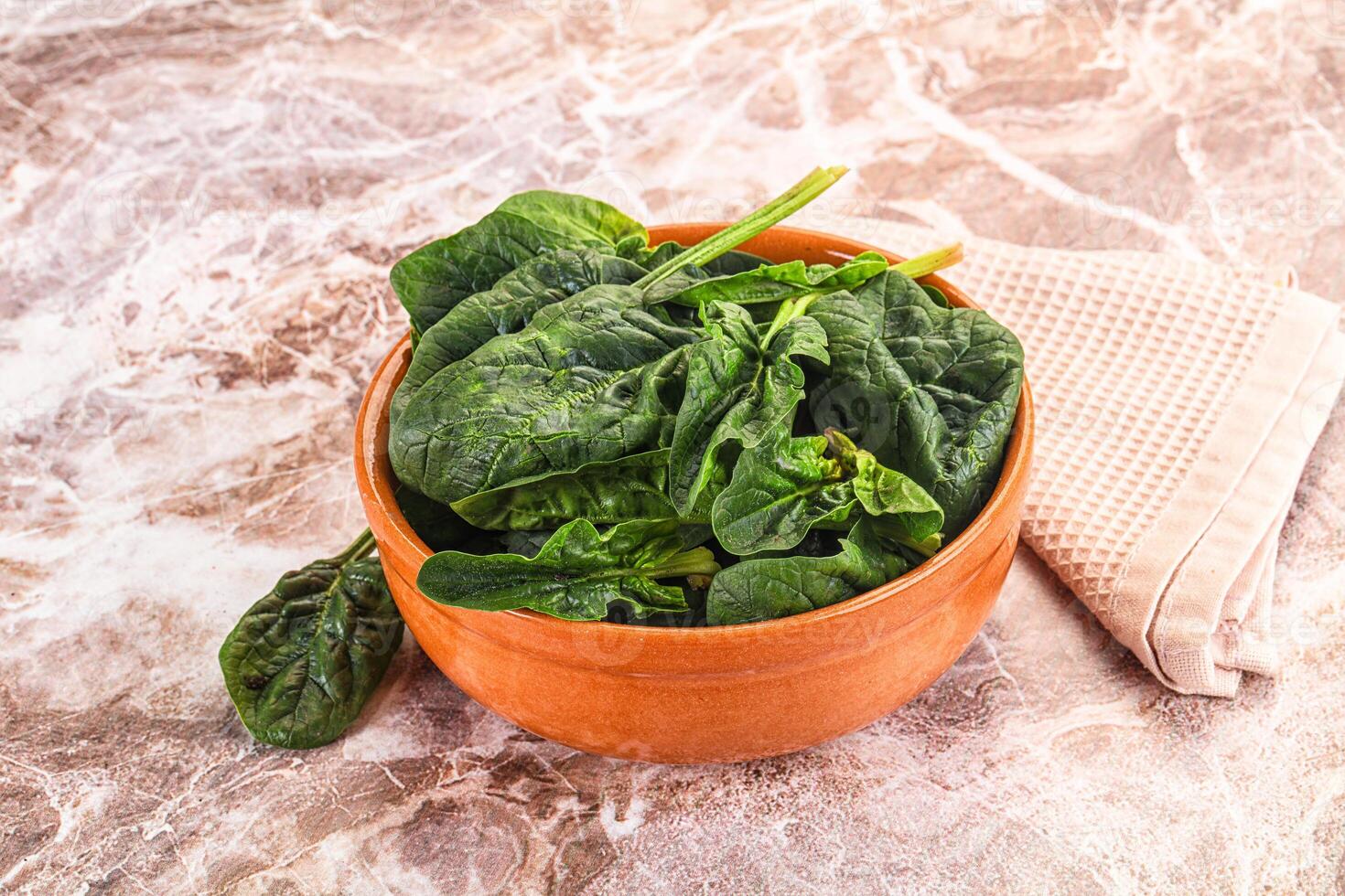 A bowl of spinach on a marble counter photo