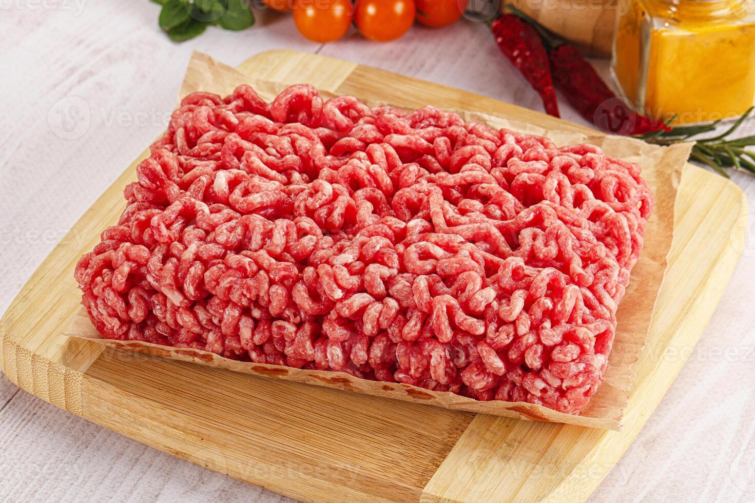 A piece of raw ground beef sitting on a cutting board photo