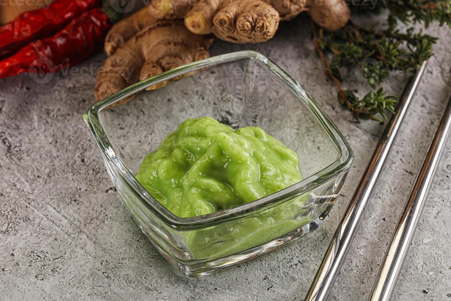 A glass container with a green sauce on it photo