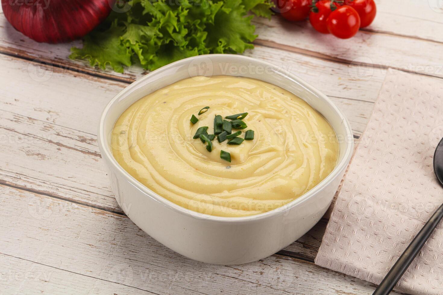 A bowl of creamy mashed potatoes with a fork and a knife photo