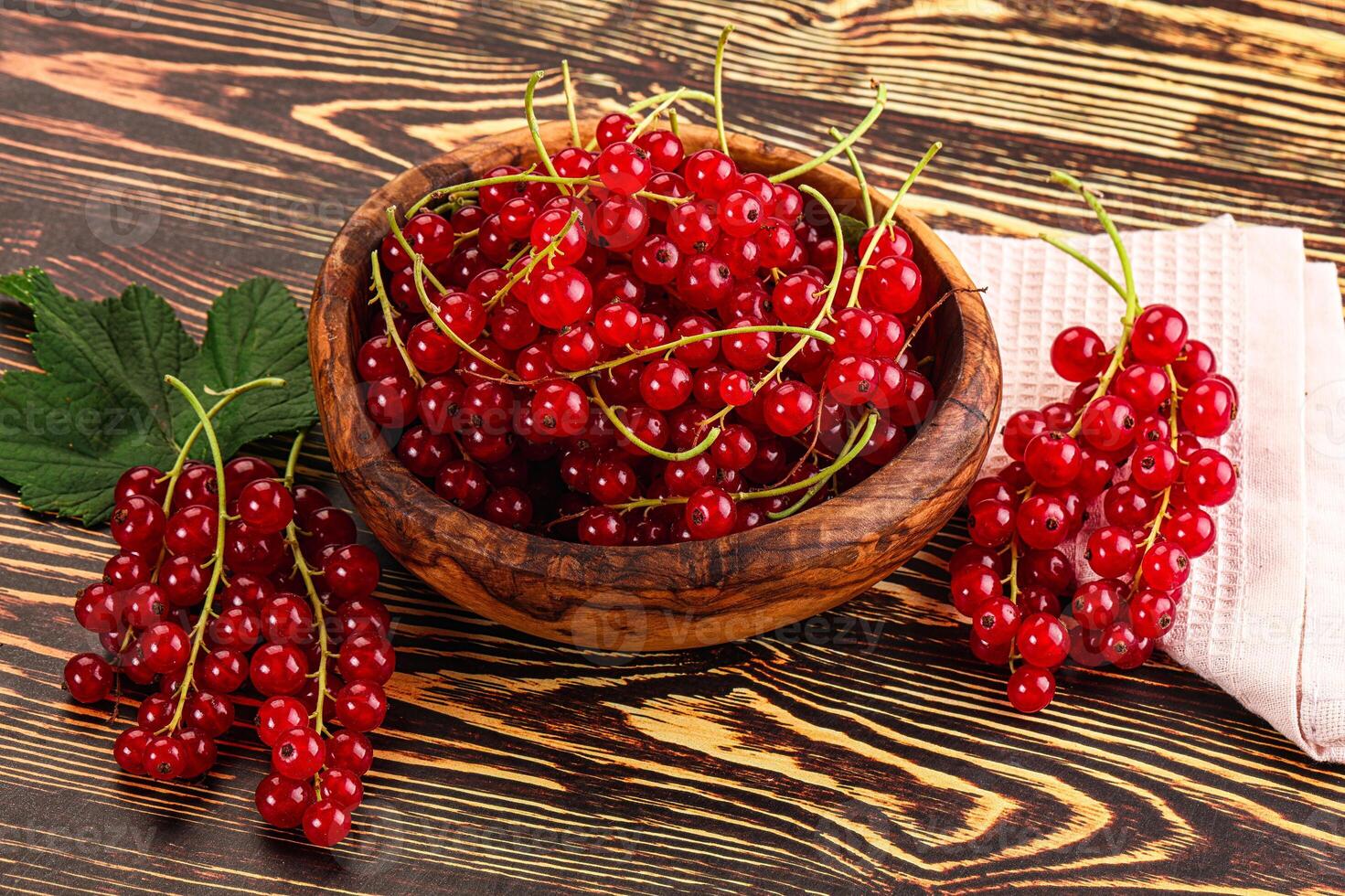 A bowl of red currants on a wooden table photo