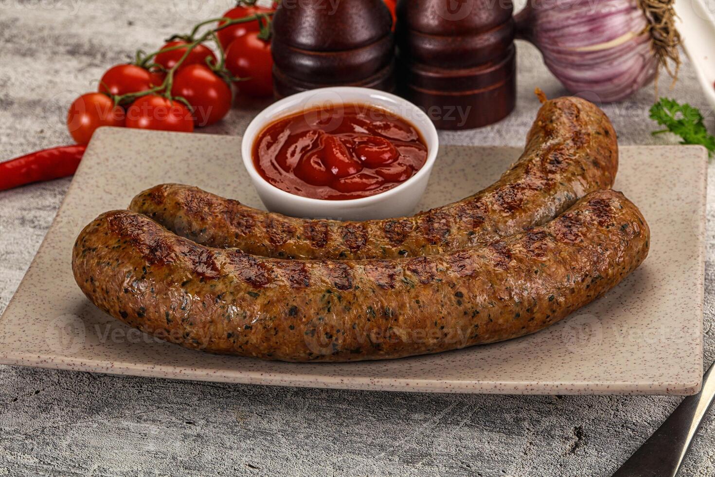Two sausages on a plate with ketchup and tomatoes photo