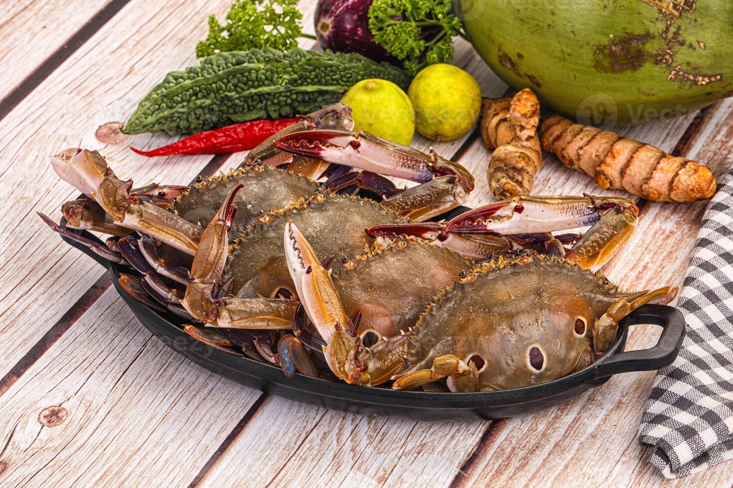 A pan of crabs and vegetables on a table photo