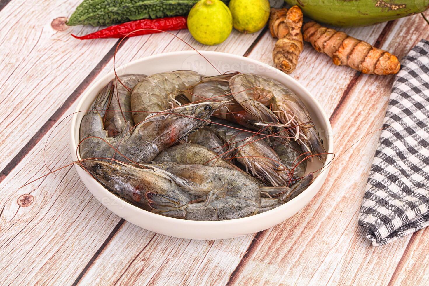 A bowl of shrimp and vegetables on a wooden table photo