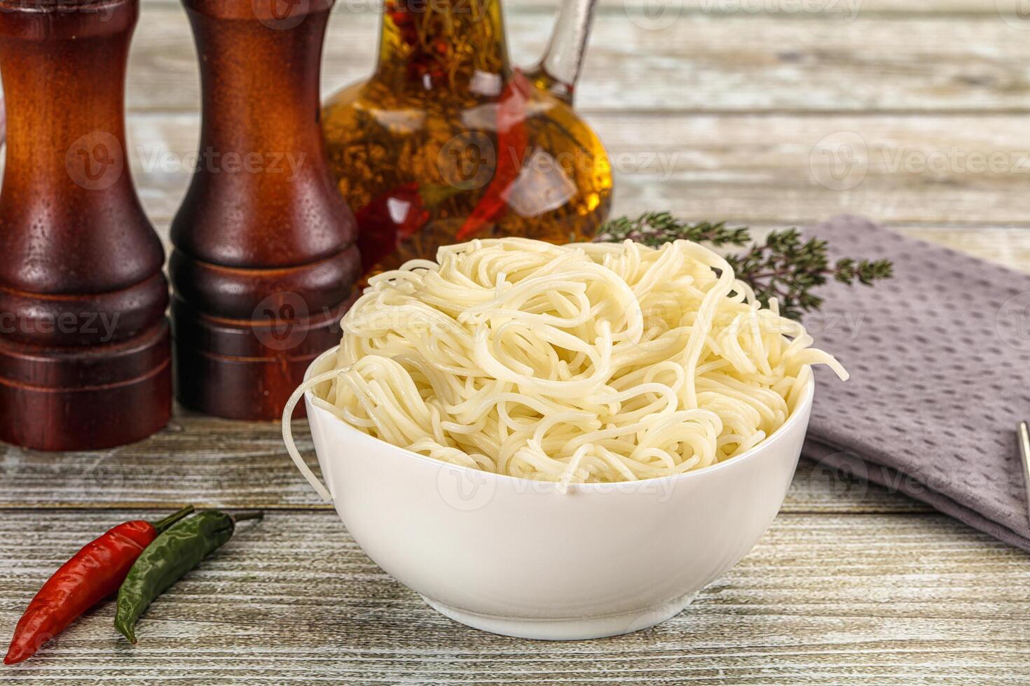 A bowl of noodles with spices and pepper photo