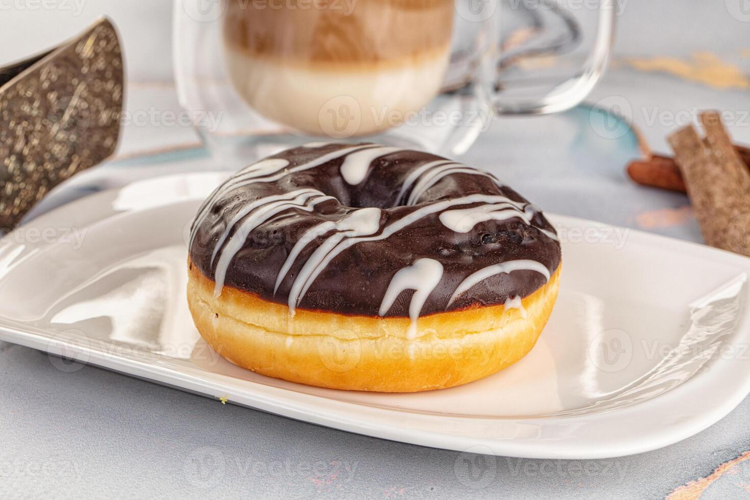 A donut on a plate with a cup of coffee photo