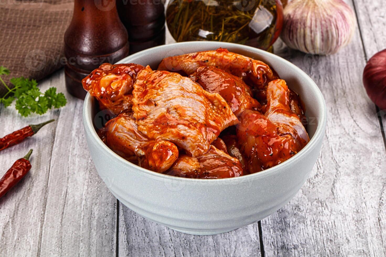 A bowl of chicken wings with sauce and garlic photo