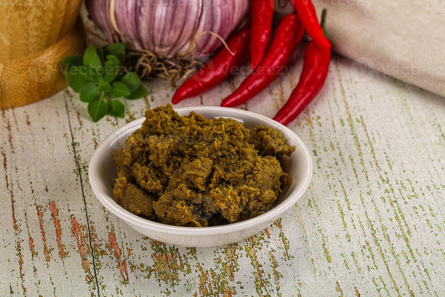 A bowl of curry with spices and a knife photo