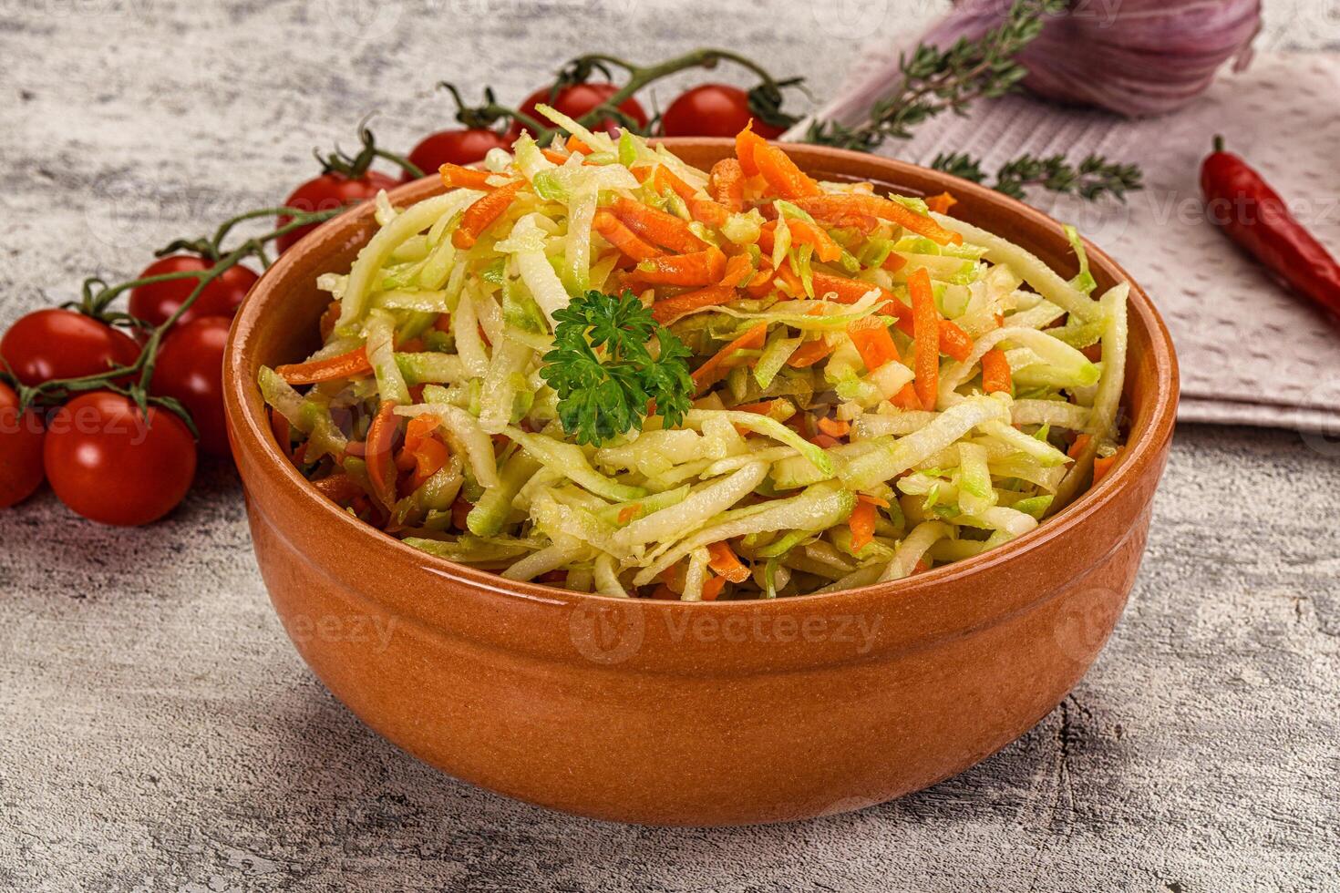A bowl of coleslaw with carrots and tomatoes photo