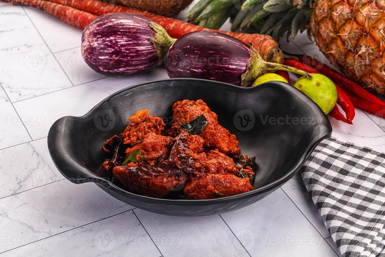A bowl of food sitting on a counter next to a bunch of vegetables photo