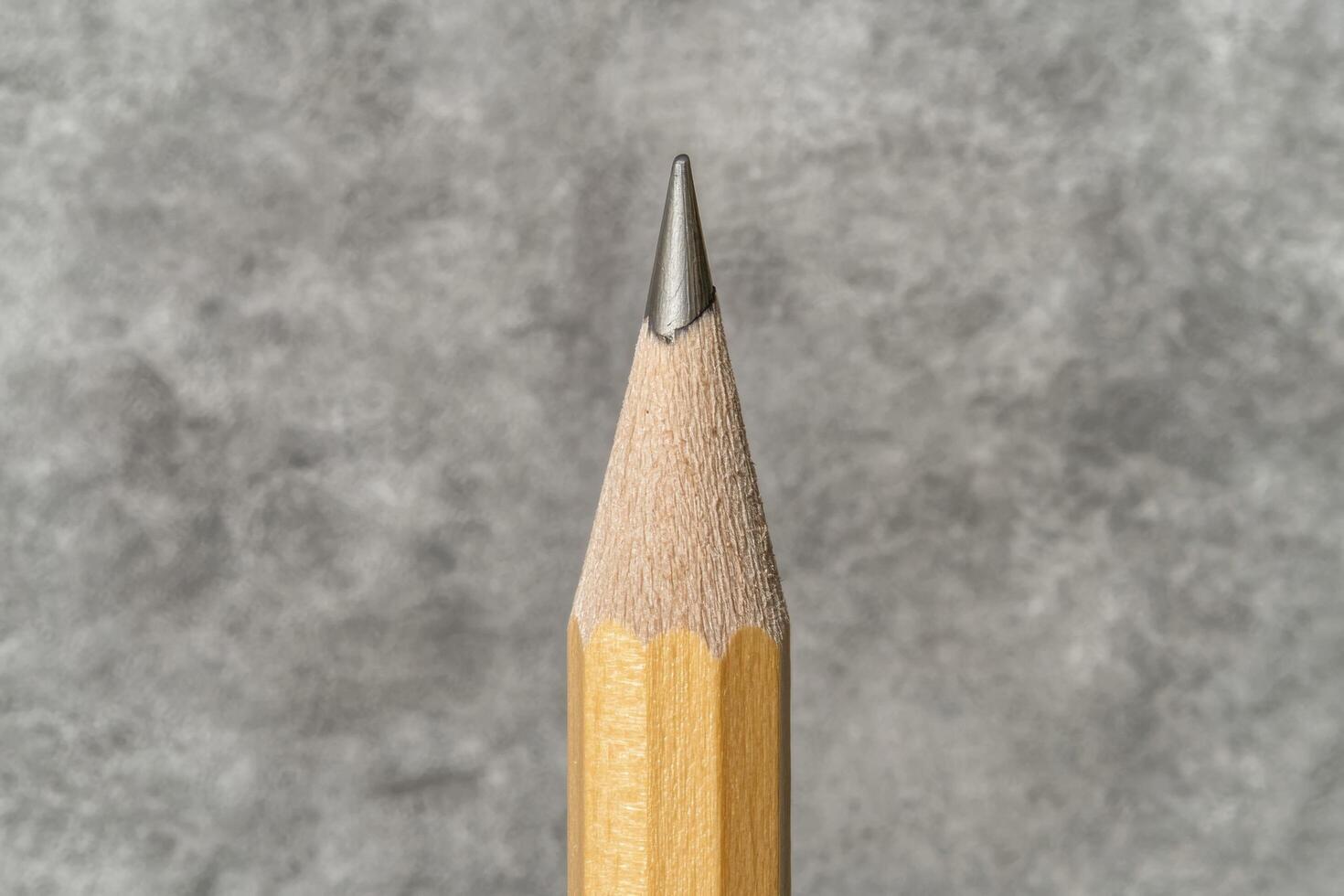 Close up of a sharpened pencil against a textured background photo