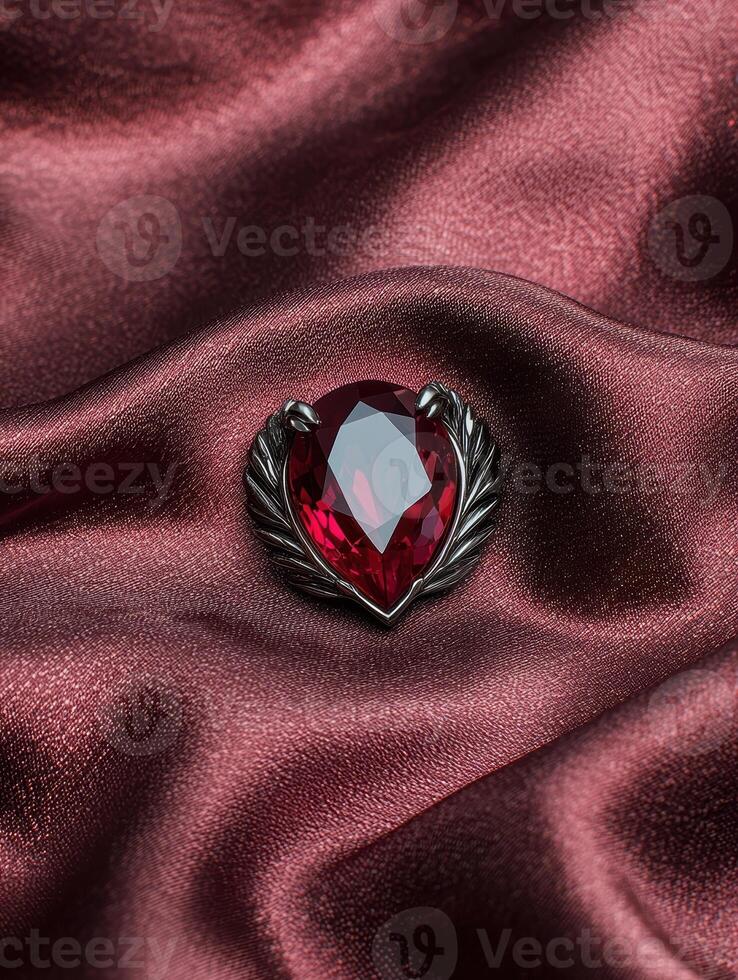 A ruby gemstone brooch on a silk fabric photo