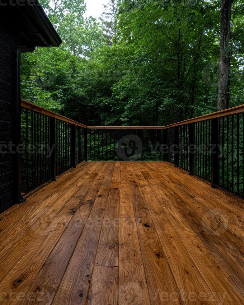A wooden deck with a railing overlooks a lush green forest photo