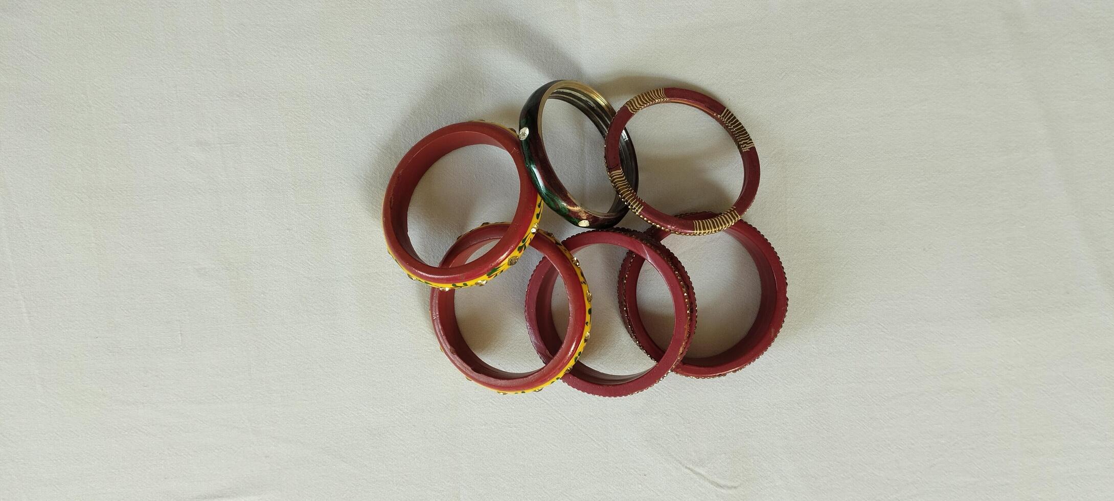 A beautiful collection of traditional Indian bangles in red, gold, and green, featuring intricate detailing. These handcrafted accessories symbolize grace, tradition, and celebration. photo