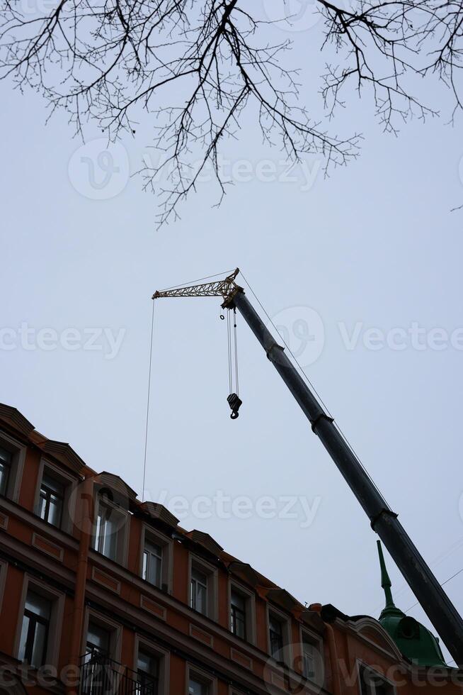 An Overhead Crane in Operation During a Building Renovation Project During the Daytime photo