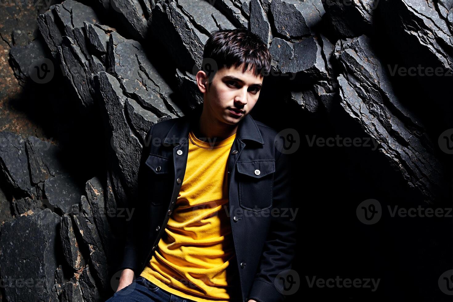 A man sitting on a rock wall photo